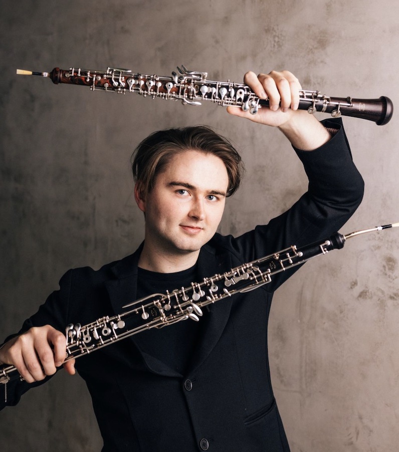 Musician holding oboes in both hands up to the camera
