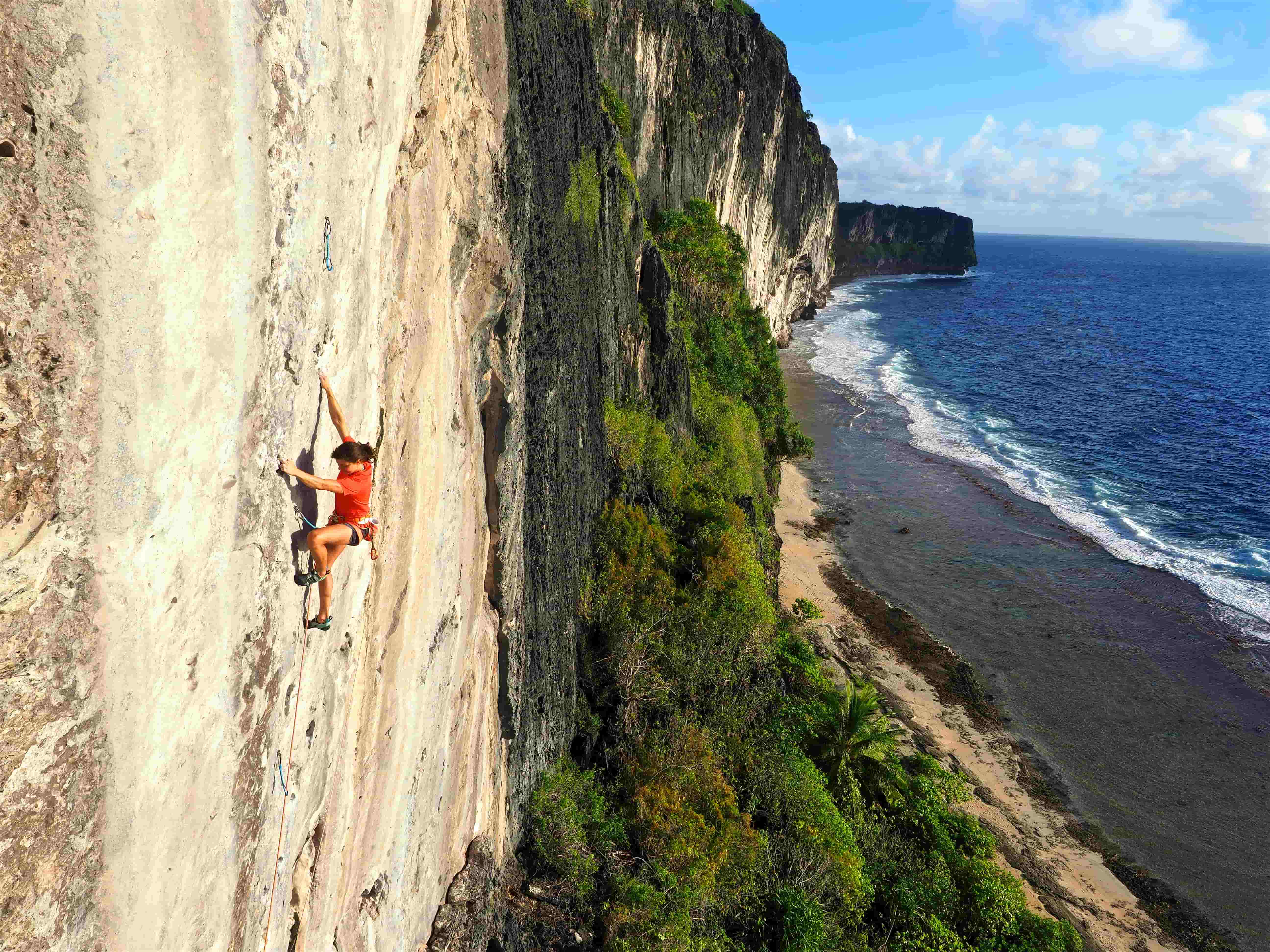 A female athlete is climbing on the coast. 