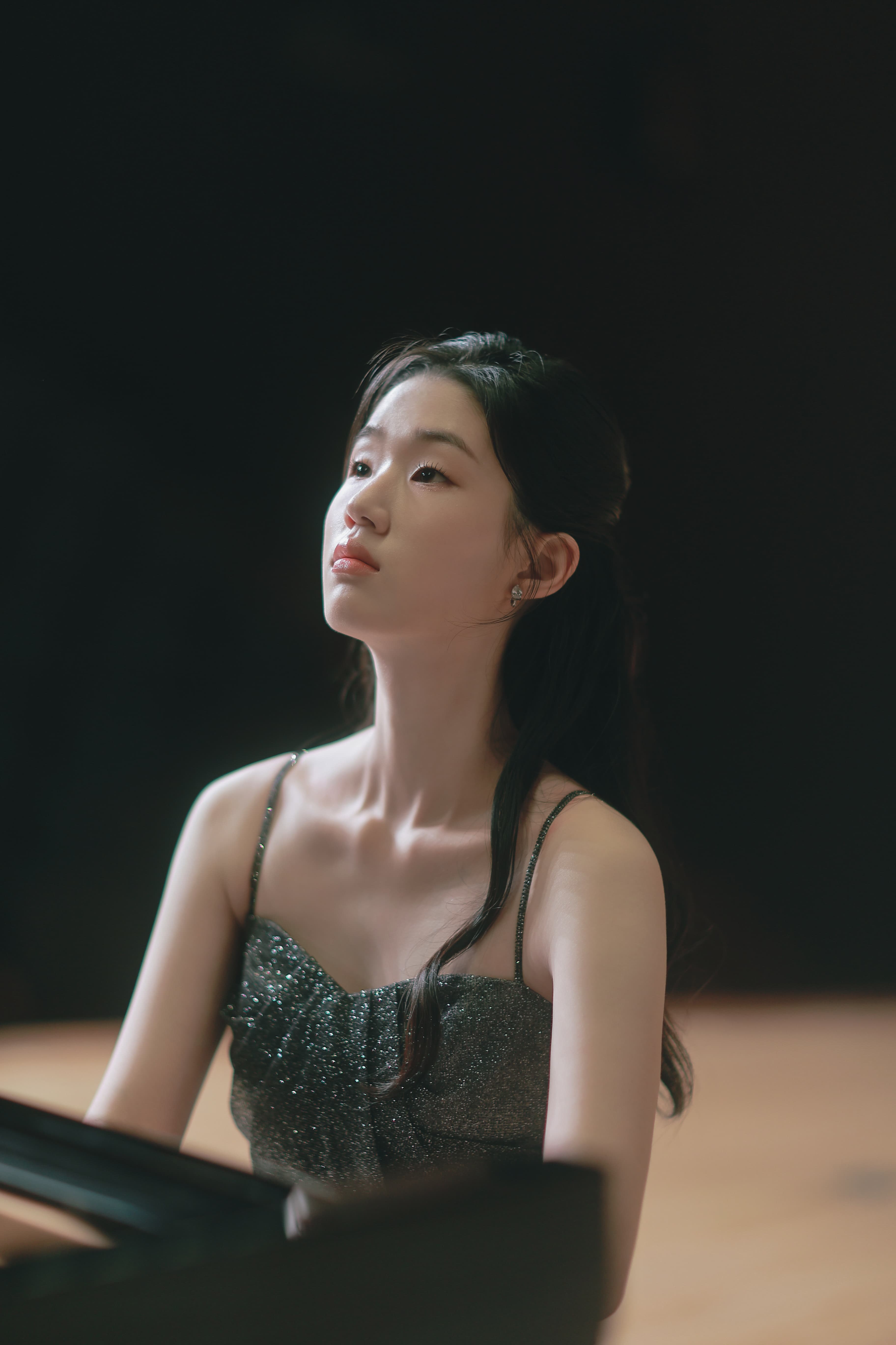 Woman sitting at the piano looking off camera