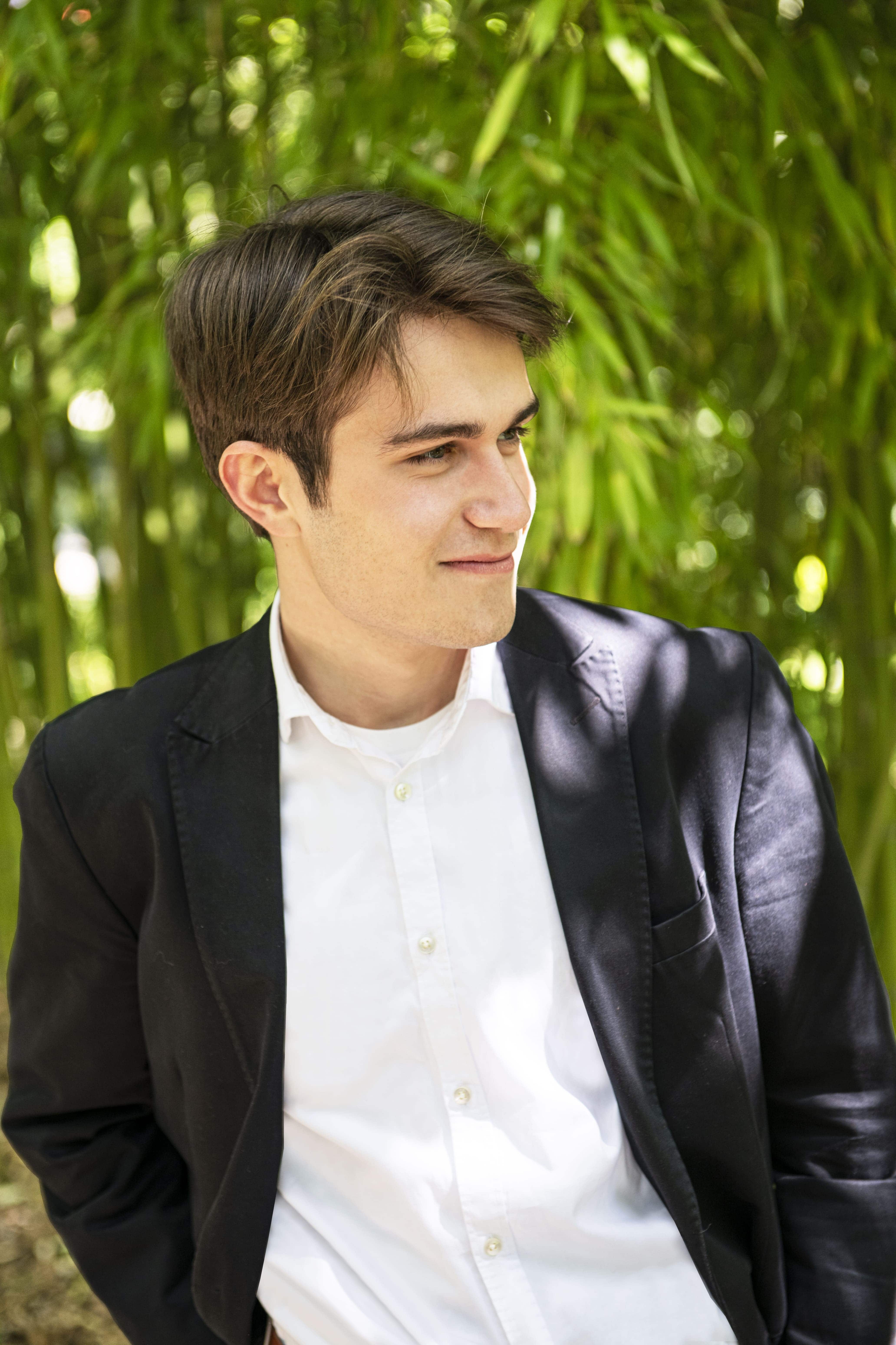 Man in black jacket and white shirt looking to the right of the camera