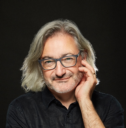 Headshot of author Gary Barwin wearing a black collared T in front of a black background.