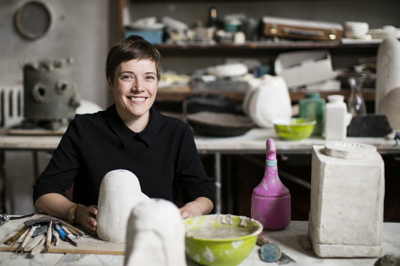 Emma Hart in a studio with a potential sculpture of clay in her hands.