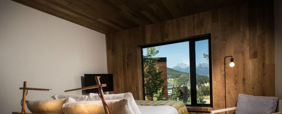 Wood finished Lloyd Hall hotel room with a mountain view out the window.