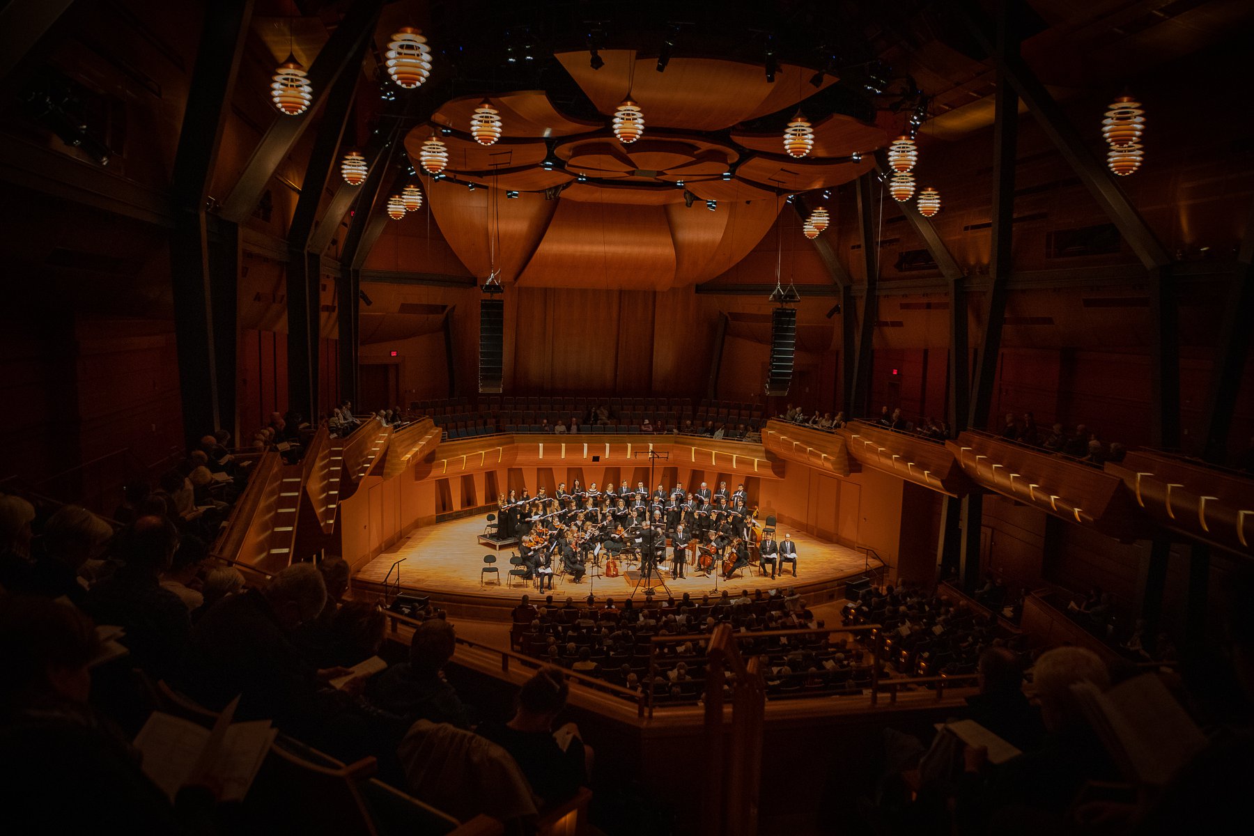 Luminous voices choir performs in a beautifully finished large dome shaped wood auditorium.