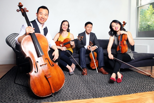 4 musicians of the Parker Quartet, 1 Bassist and three violinists in a casual setting.