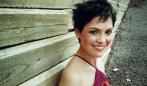 Susan Aglukark smiles in front of a retaining wall of 8x8's
