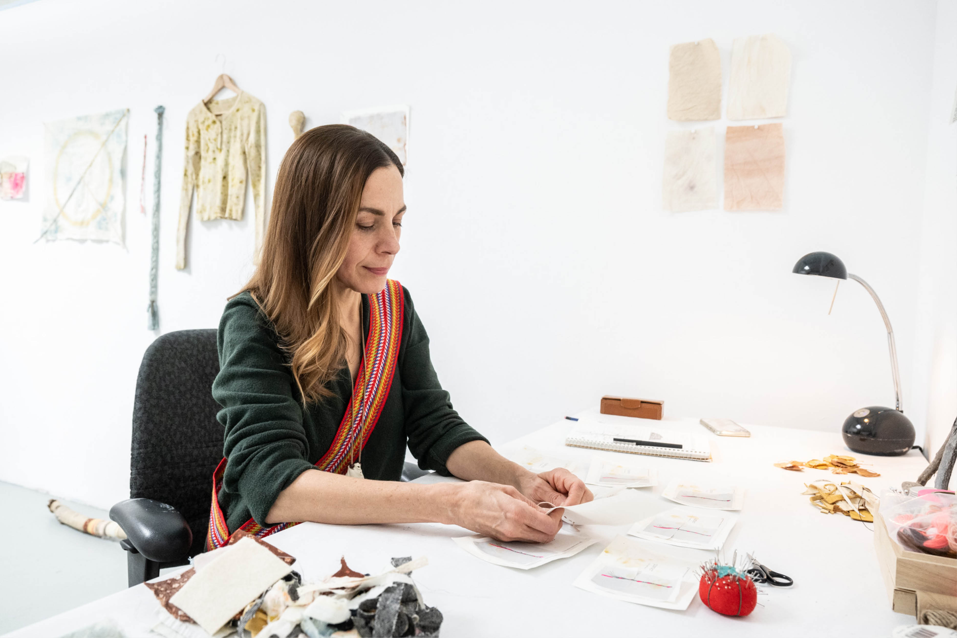 An artist is working at a table in a studio