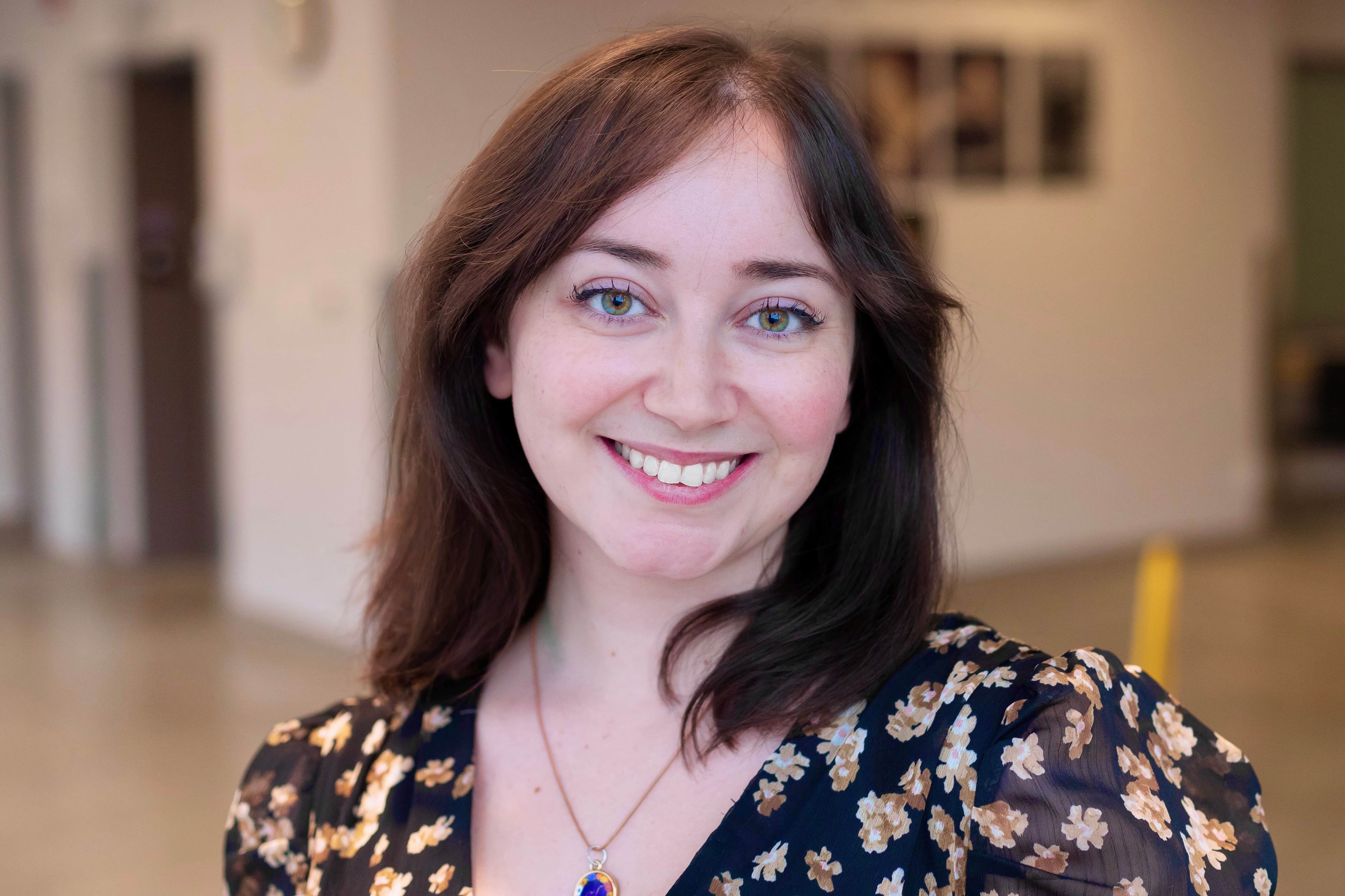 Woman with dark brown shoulder length hair smiling directly at the camera