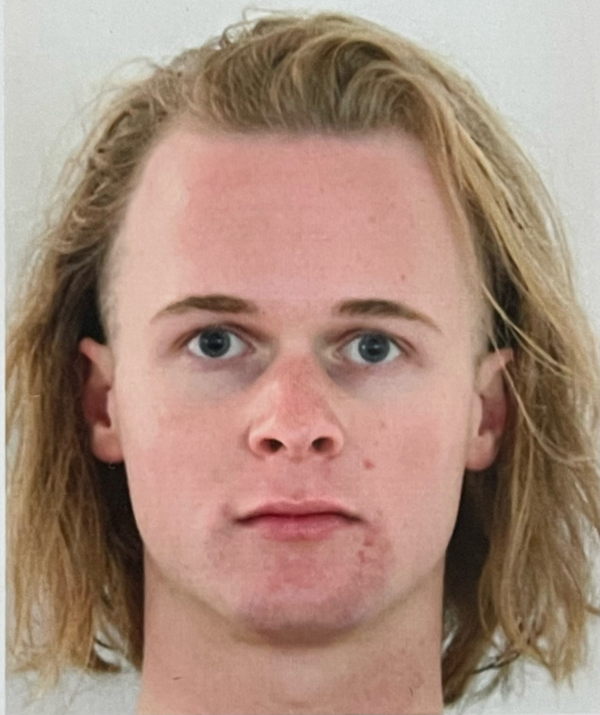 Man with shoulder length hair staring directly at the camera