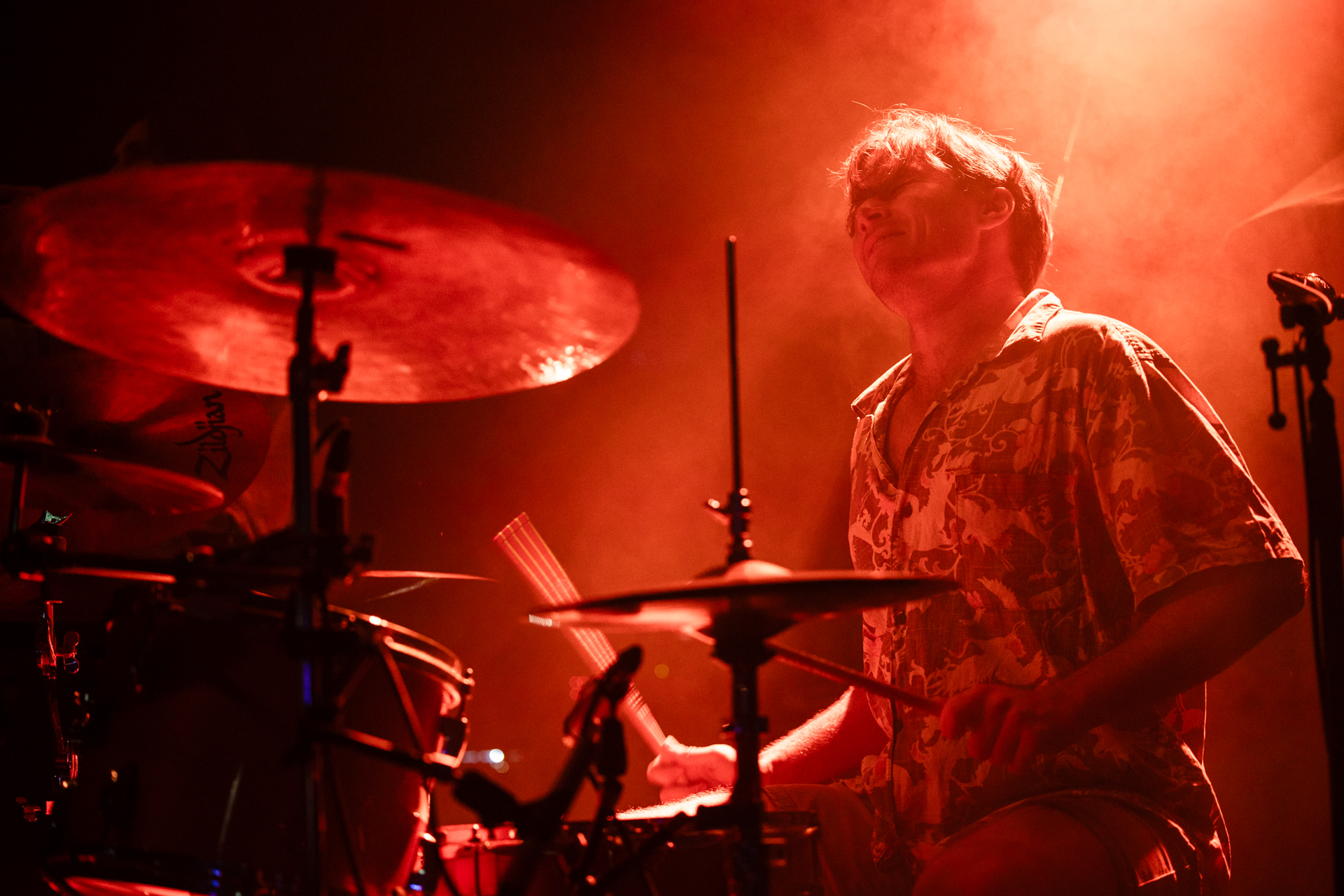 Drummer behind a drum set playing during a performance