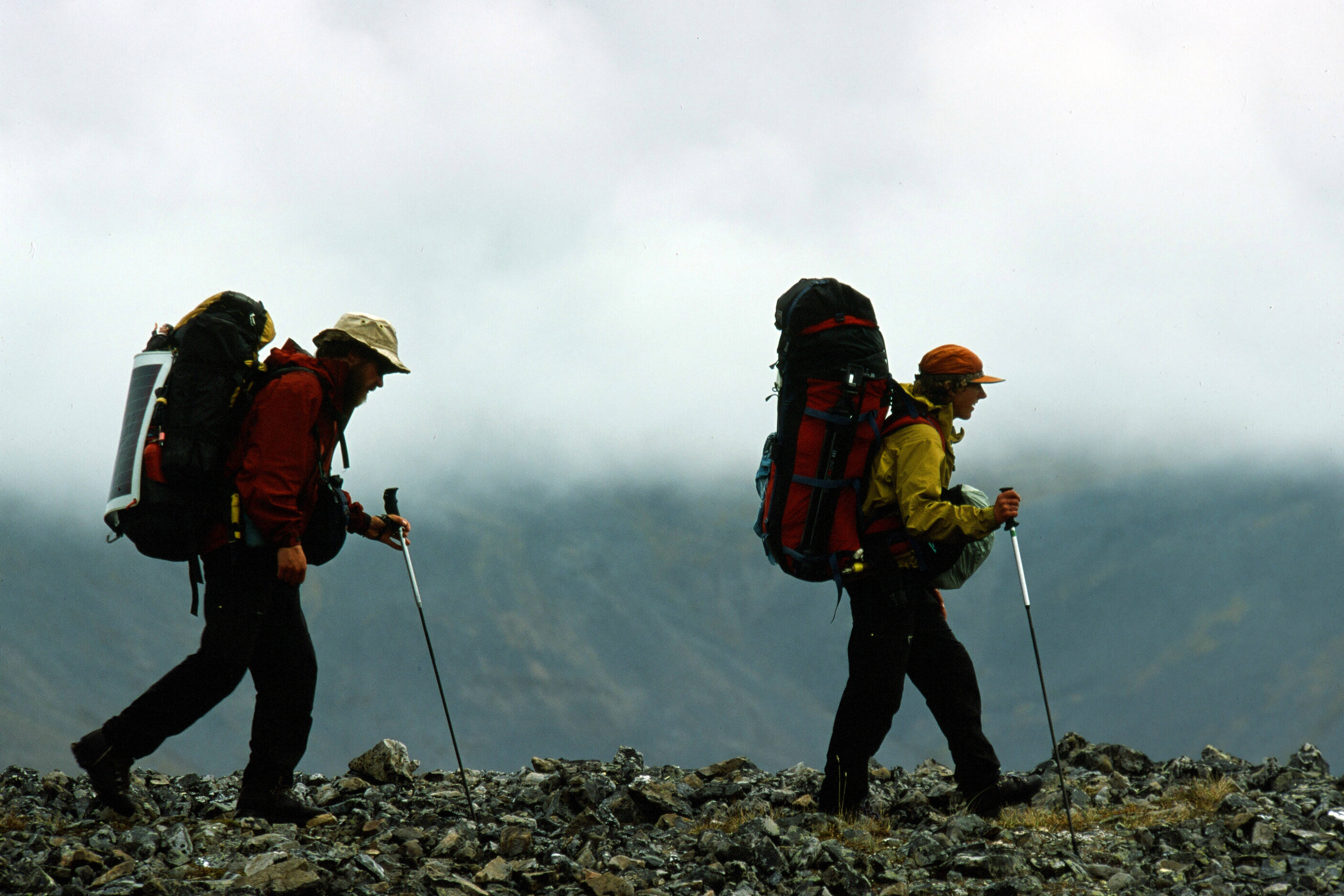 Karsten and Leanne hike on a rocky ridge with large backpacks