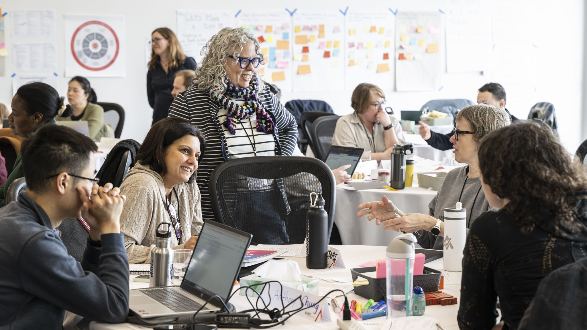 A group of people are engaged in a lively discussion in a classroom