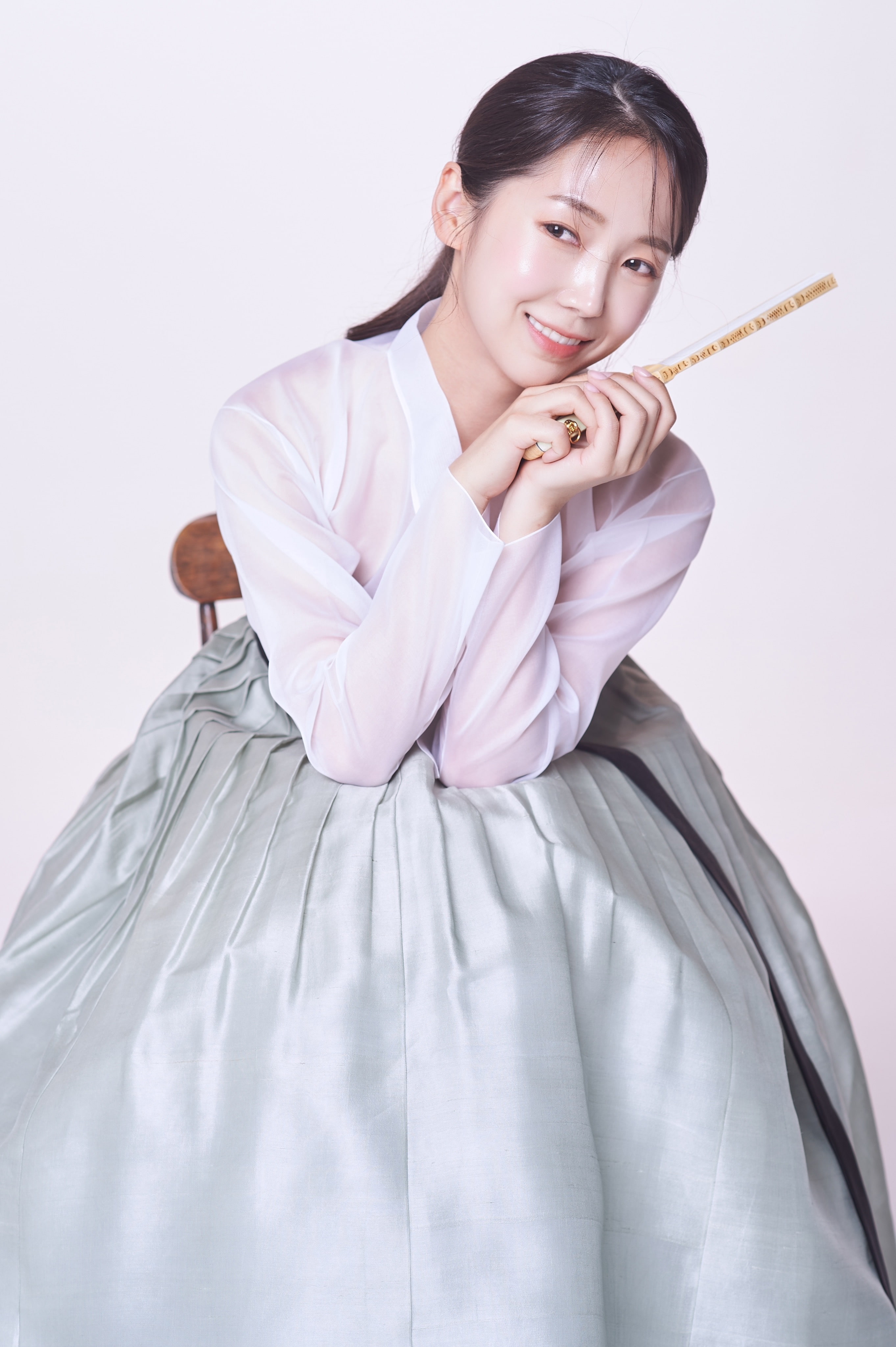 Person in purple gown holding yellow object smiling 