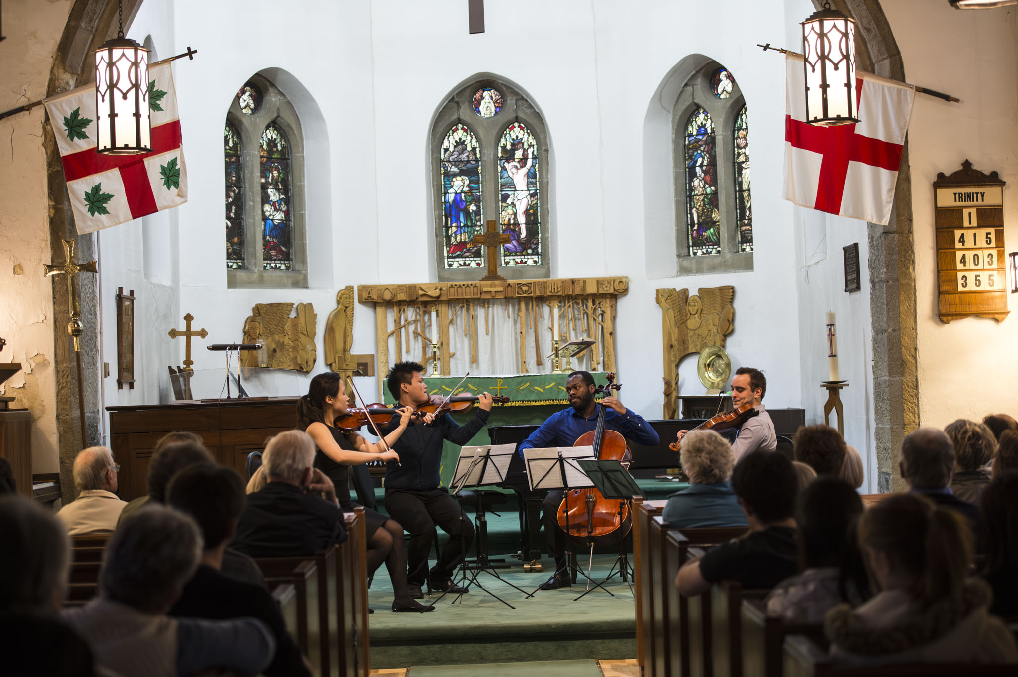 Chamber Music Musicians playing in a church with audience seating on banches