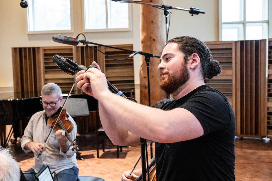 An audio engineer is adjusting a microphone 