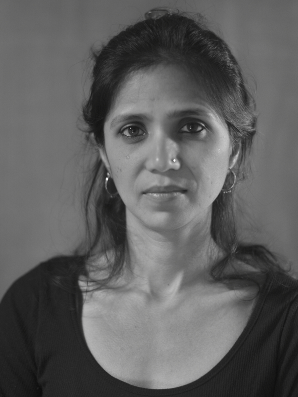 Woman in black and white photo with shoulder length hair staring directly at camera