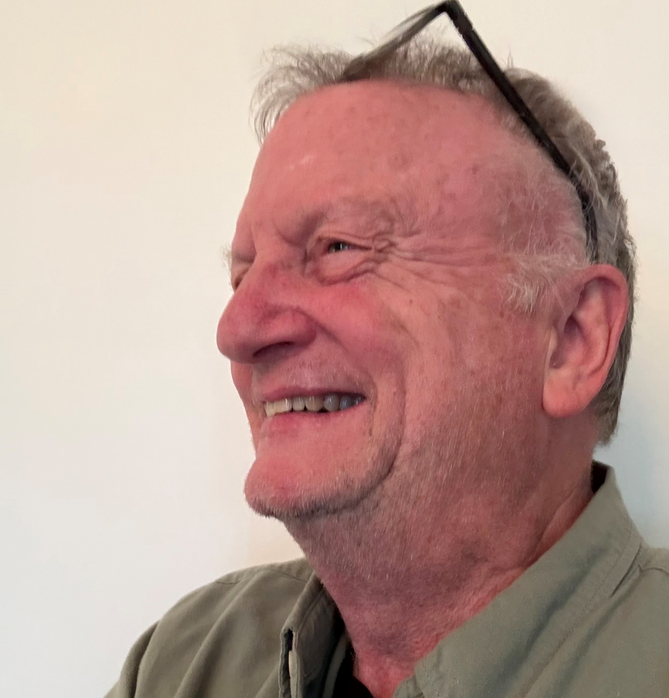 Man smiling broadly looking off to the side of 