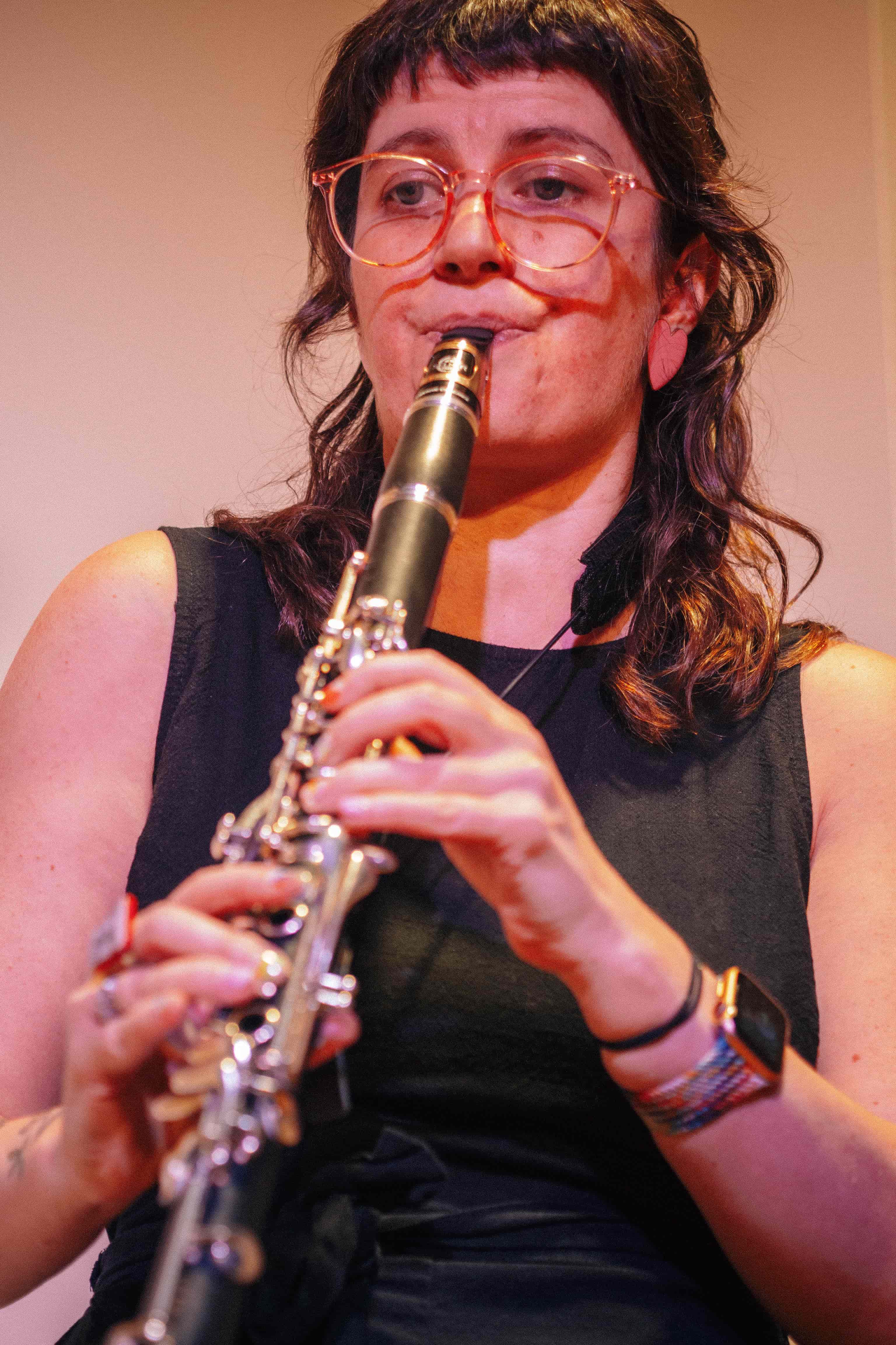 Woman playing clarinet and looking off centre