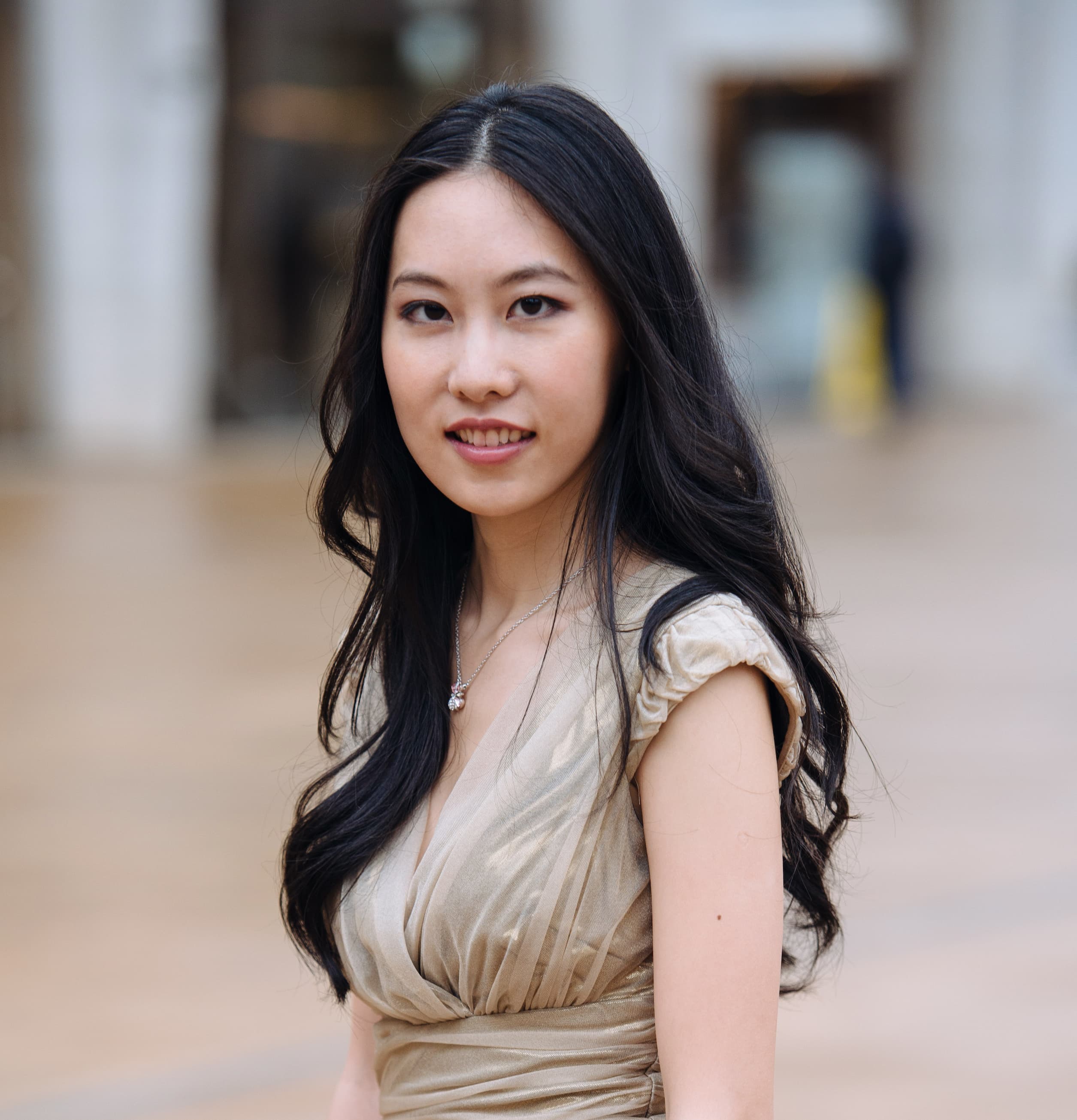 Woman in beige top and long black hair looking at the camera