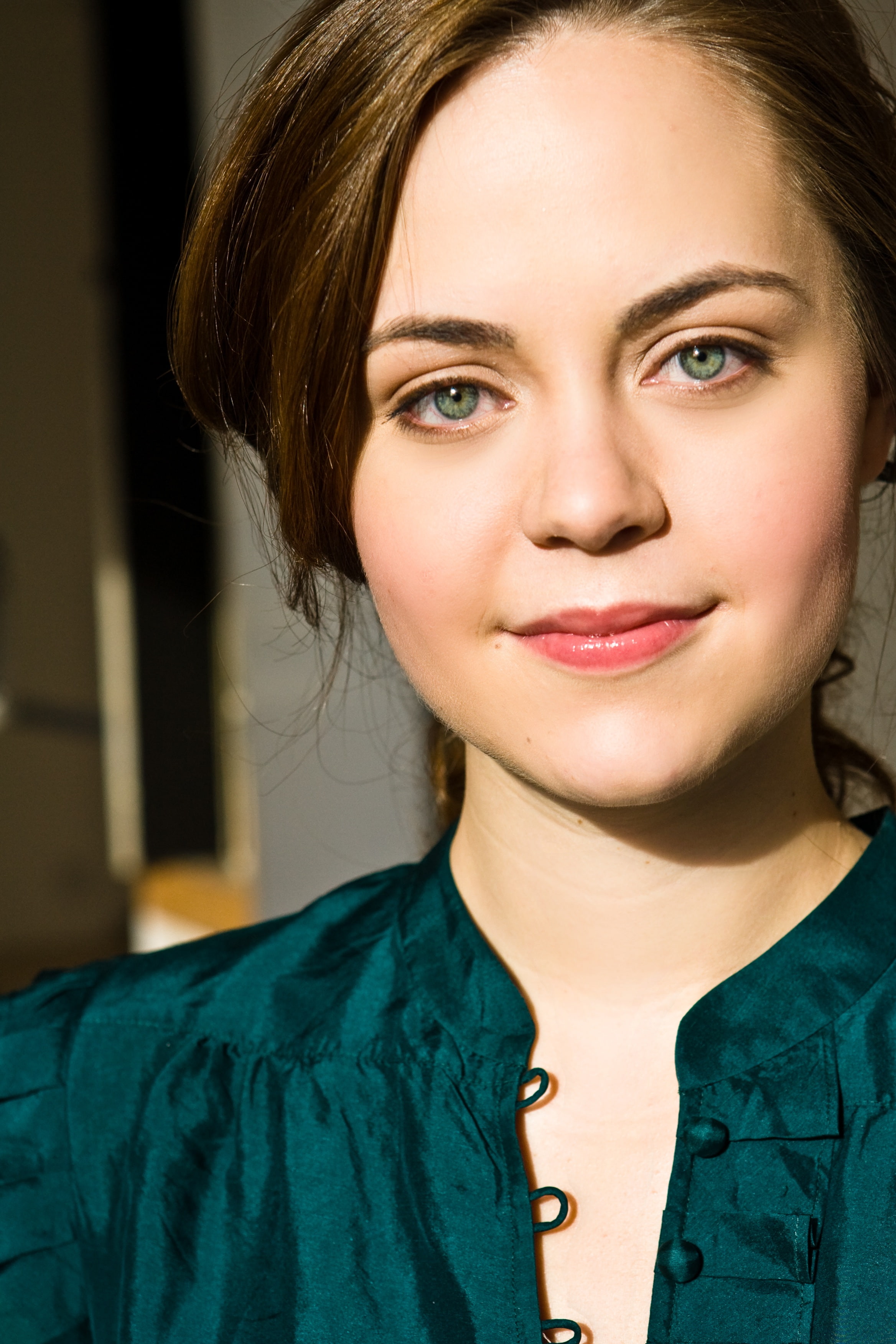 Close up shot of woman looking directly at camera and smiling slightly
