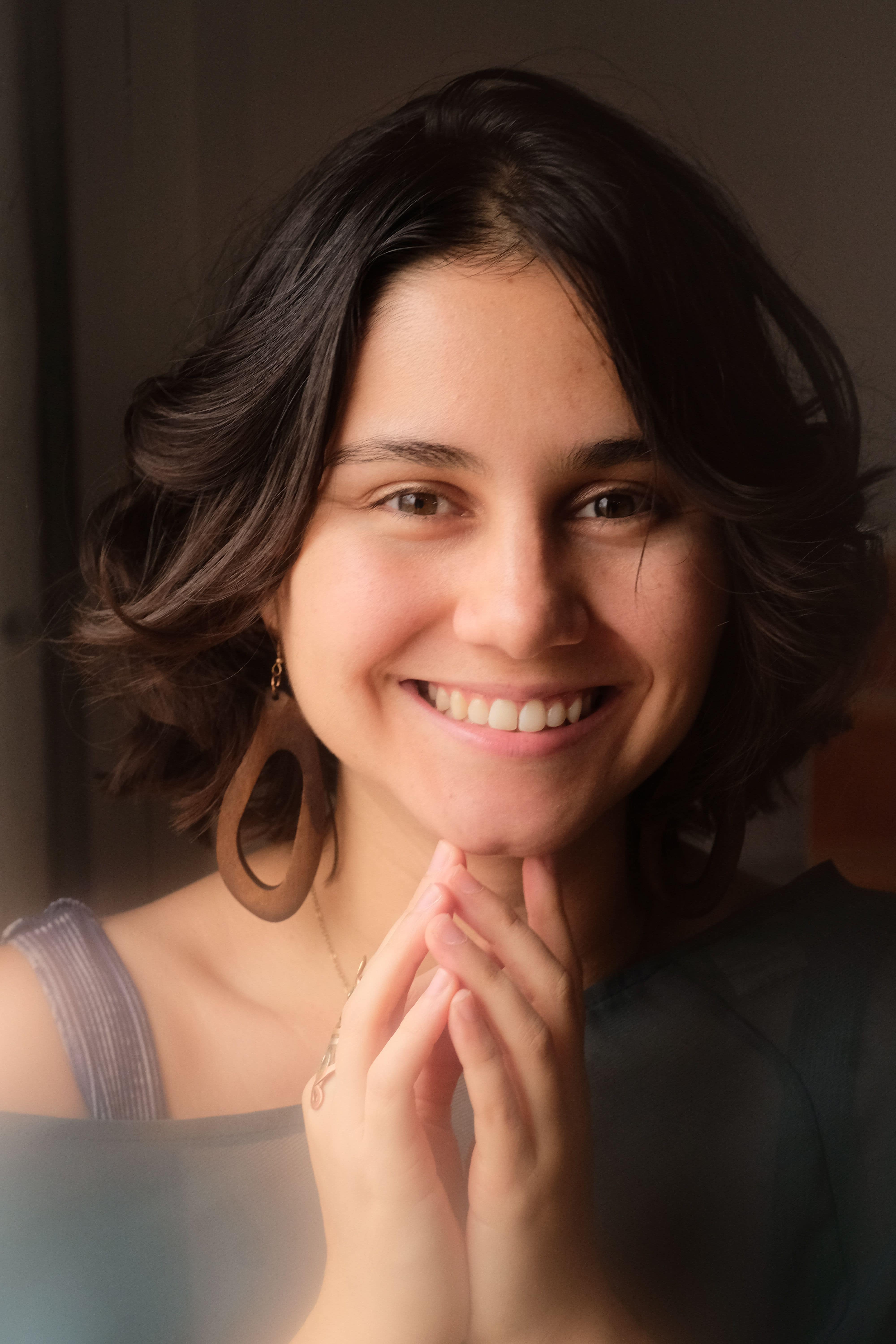 Person with long brown hair smiling at the camera