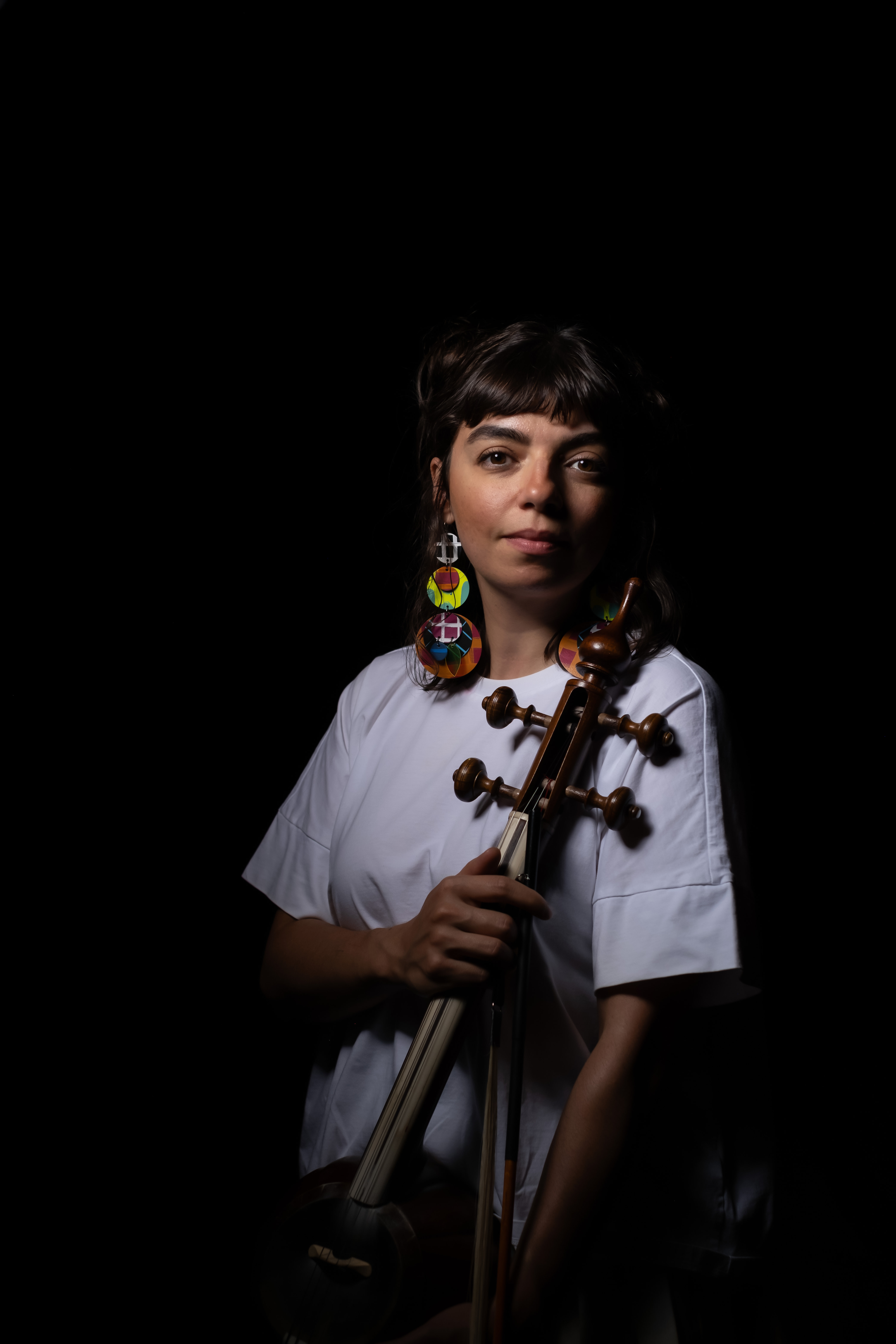 Person looking into the camera holding a string instrument