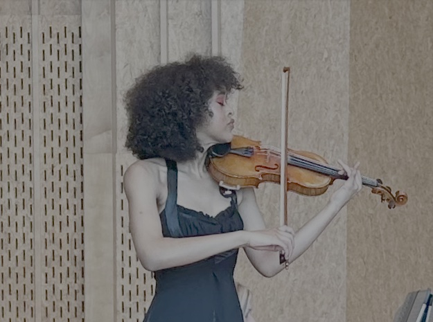 Woman in black gown and red heels playing violin in concert