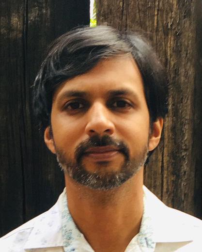 Man with short dark hair looking directly into the camera