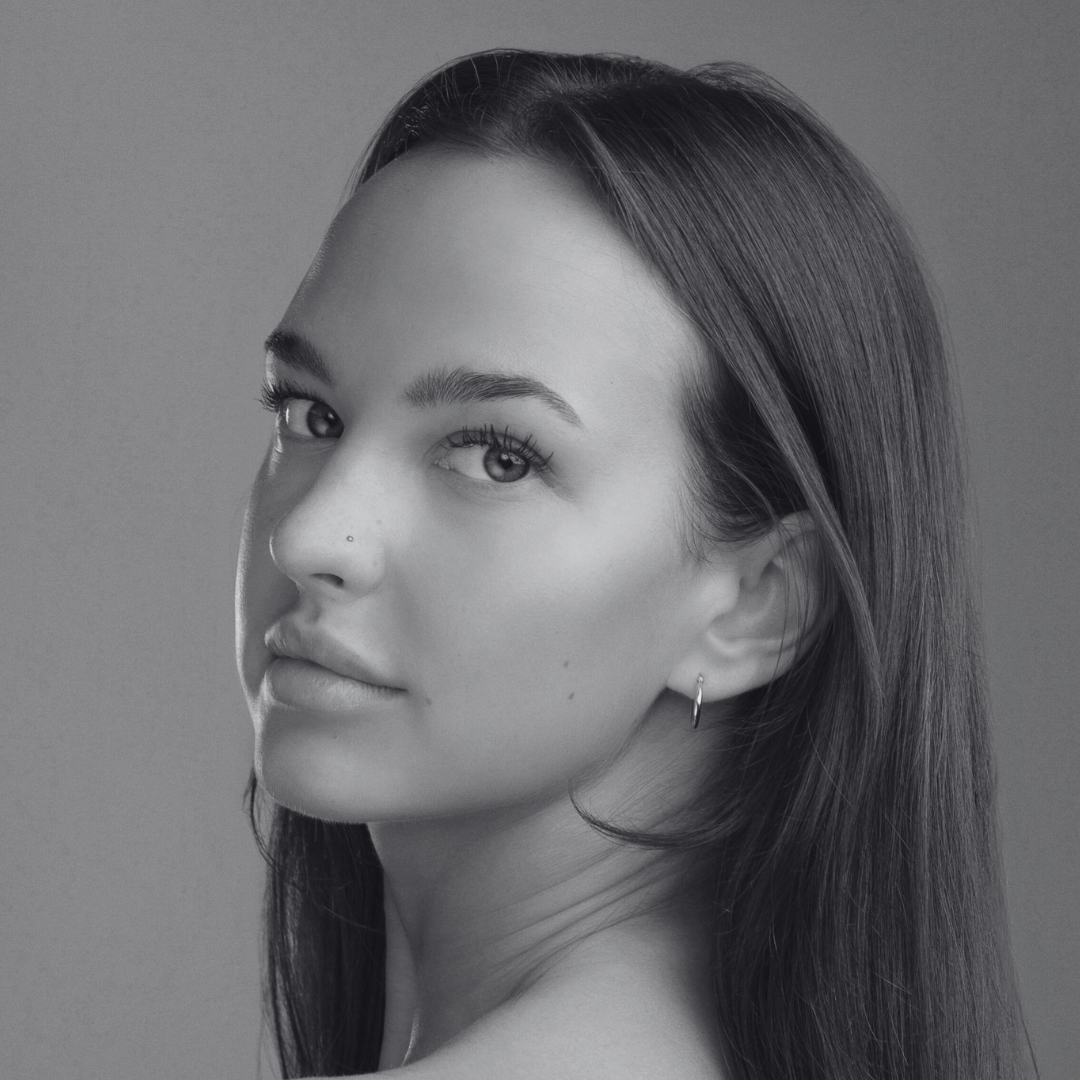 Black and white photo of woman looking at camera from the side