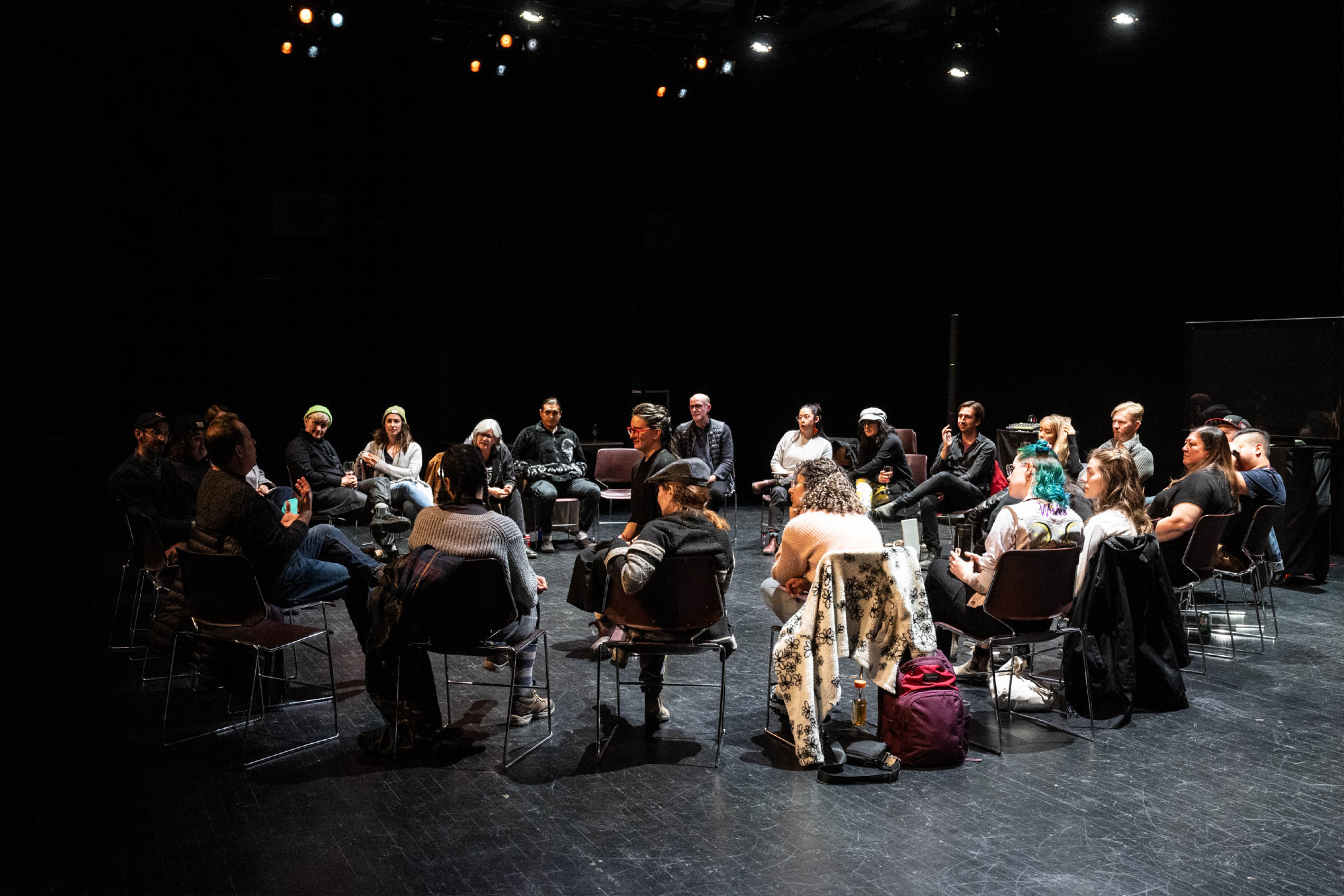 A group of playwrights are sitting in a circle