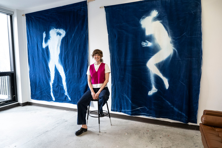 Early Career Banff Artist in Residence | Banff Centre for Arts and Creativity An artist is sitting in front of two large tapestries