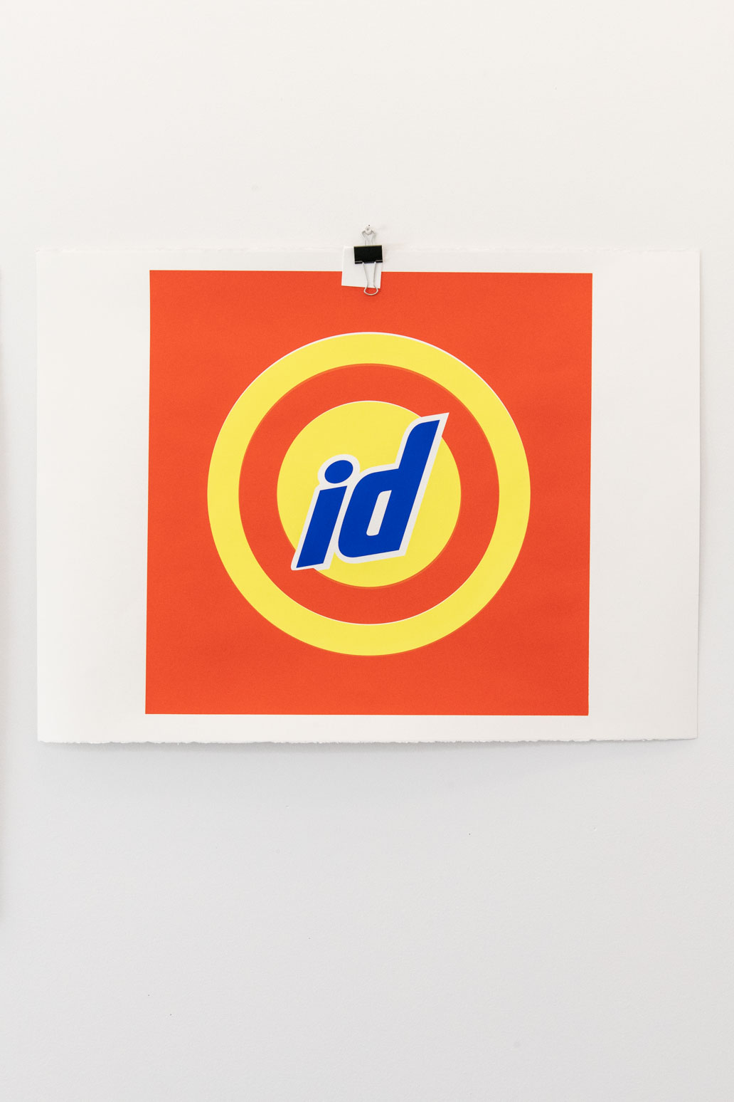 Single artwork featuring the letters 'id' overtop yellow circles on a orange background hanging on the wall of Dana's st