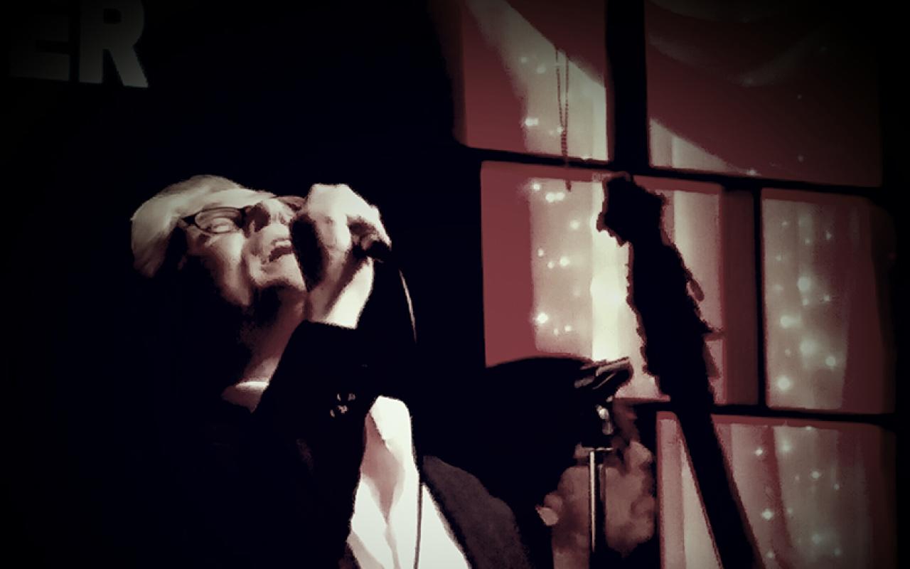 John Alcorn on the stage singing