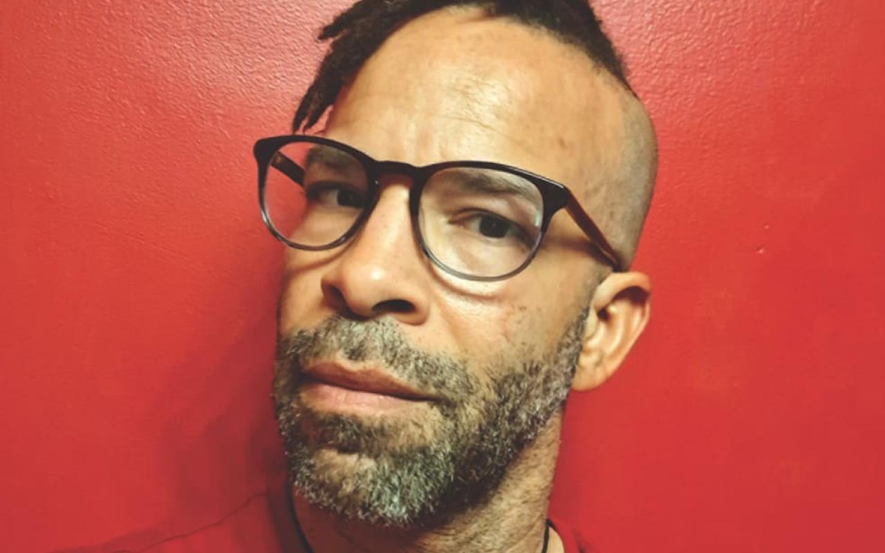 Douglas Kearney in glasses wearing a red shirt.