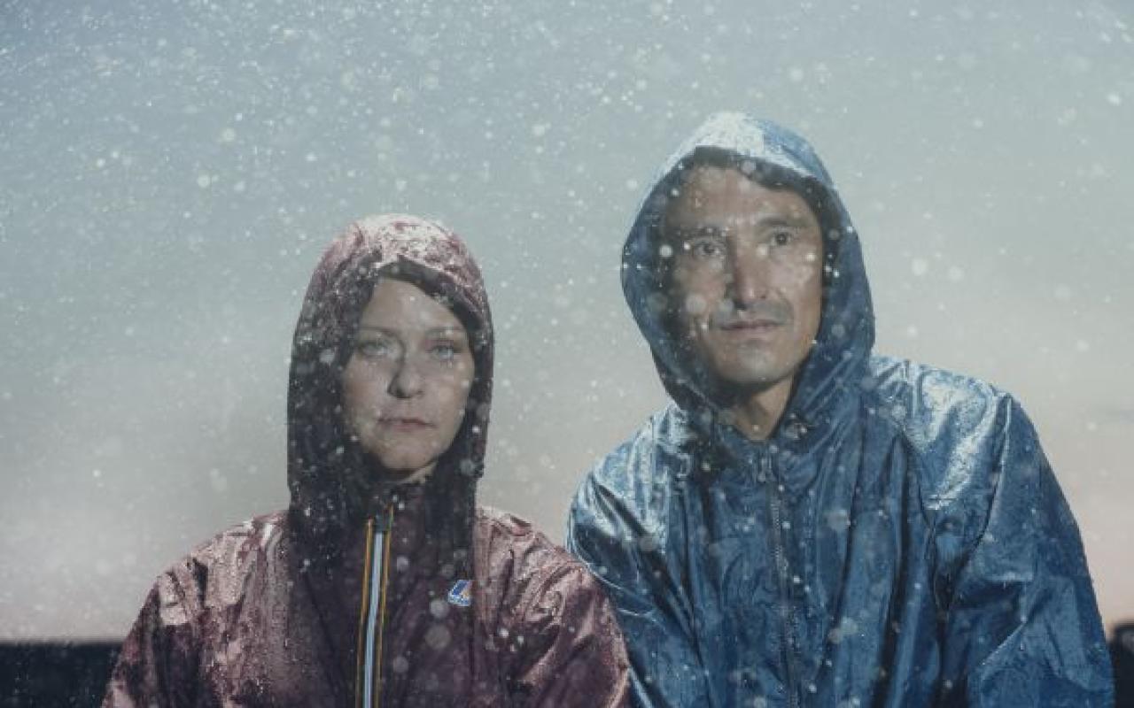 Members of the band Ghostkeeper standing with bikes in the rain.