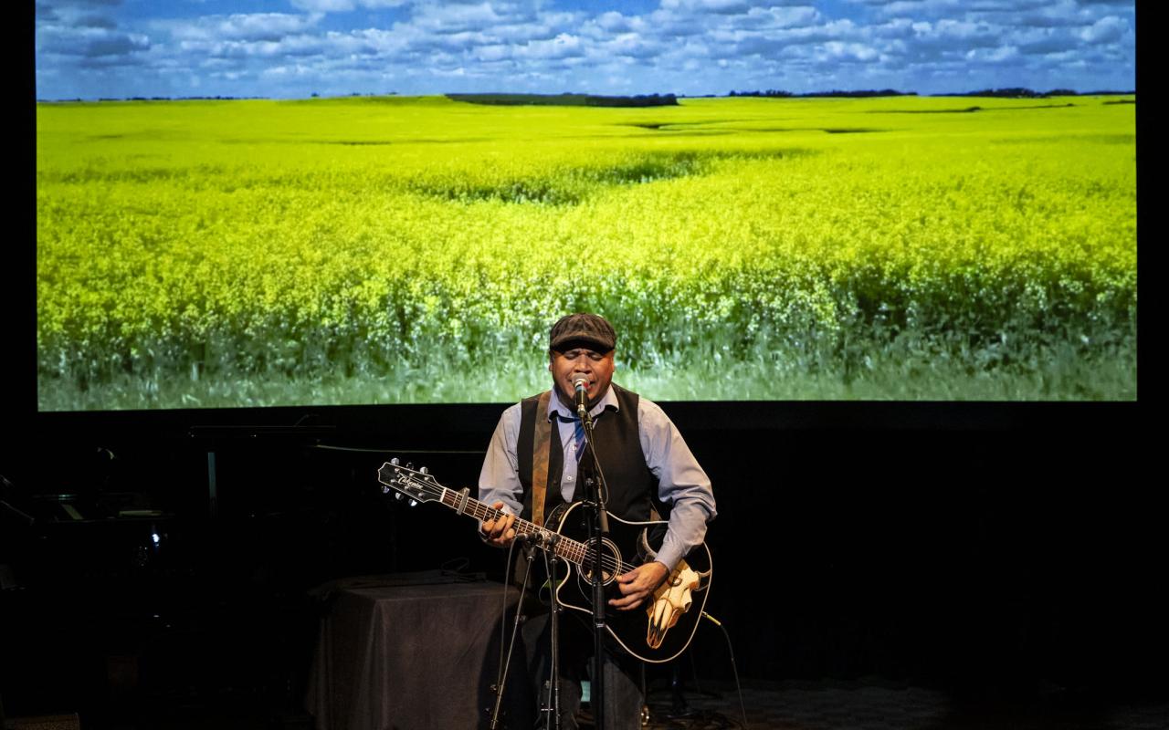 Dale Mac playing a guitar on stage
