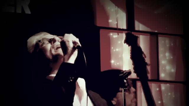 John Alcorn on the stage singing