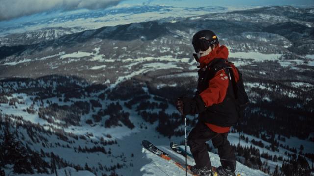 Man standing on a top of a mountain on skis 