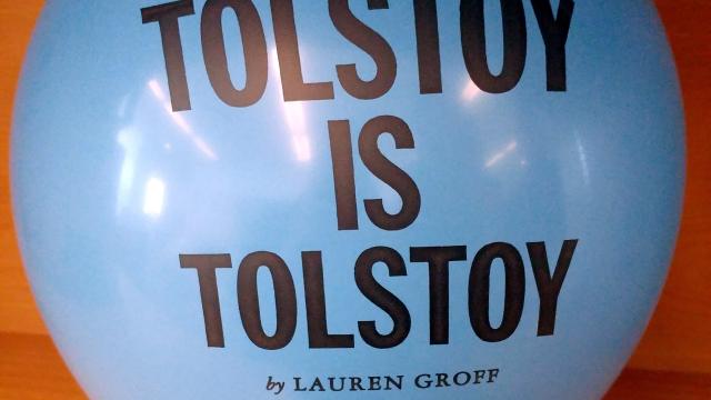 A blue balloon inflated with the text, "Tolstoy is Tolstoy by Lauren Groff," printed on it. 