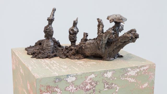 Cold-cast aluminum, resin, soil, rocks, 5 x 14 x 6 inches. The sculpture appears root-like with different protrusions, i