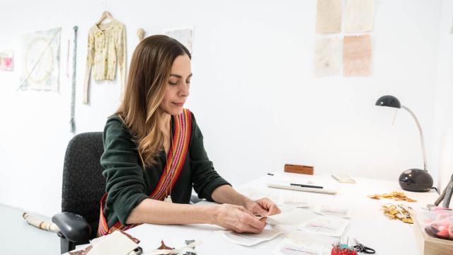 An artist is working at a table in a studio