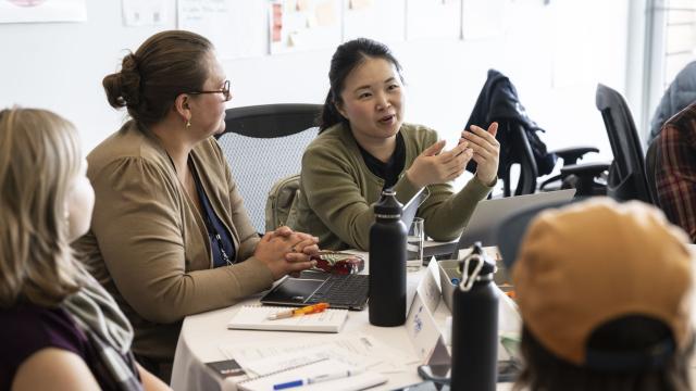 A group of people are engaged in a lively discussion in a classroom