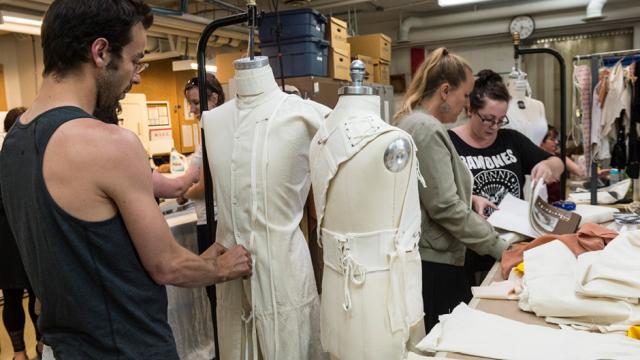 A costume designer works on a costume