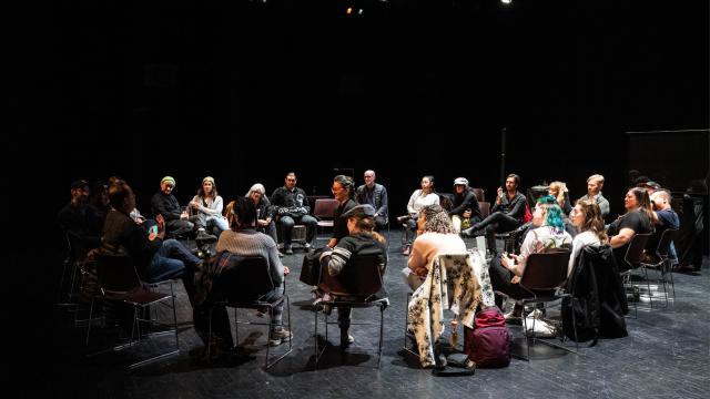 A group of playwrights are sitting in a circle