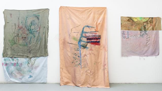 Three artworks by Maggie Crowley exhibited on the walls of her studio at Banff Centre