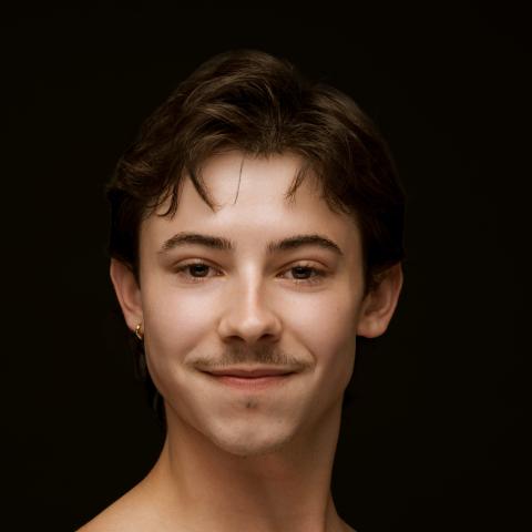 Dancer photographed from shoulders up facing the side with head turned toward camera