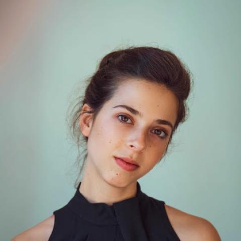 Woman staring confidently at camera in sleeveless black dress
