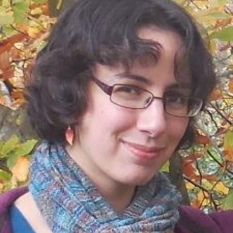 Woman with dark hair wearing a blue scarf.