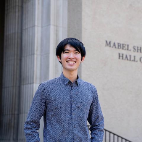 Man standing outside concert hall with a large smile