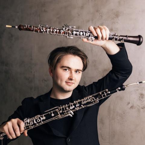 Musician holding oboes in both hands up to the camera